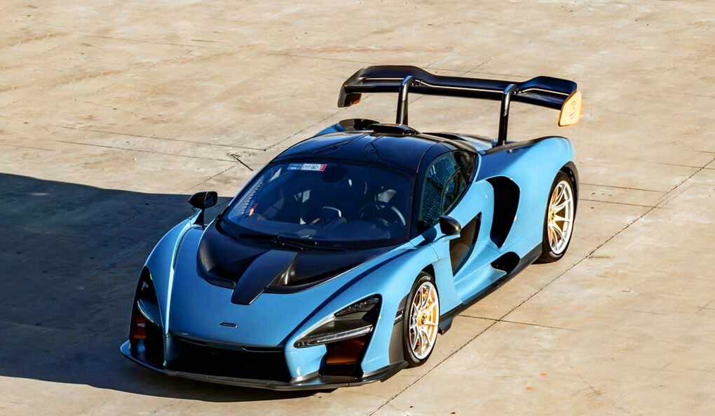 McCollisters A blue McLaren Senna sports car with a large rear wing is parked on a sunlit concrete surface, viewed from above—an ideal candidate for car shipping that emphasizes flexibility in auto transport solutions.
