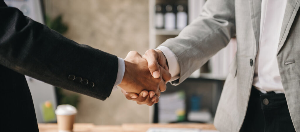 two confident business man shaking hands during a meeting in the office, success, dealing, greeting and partner in sun light